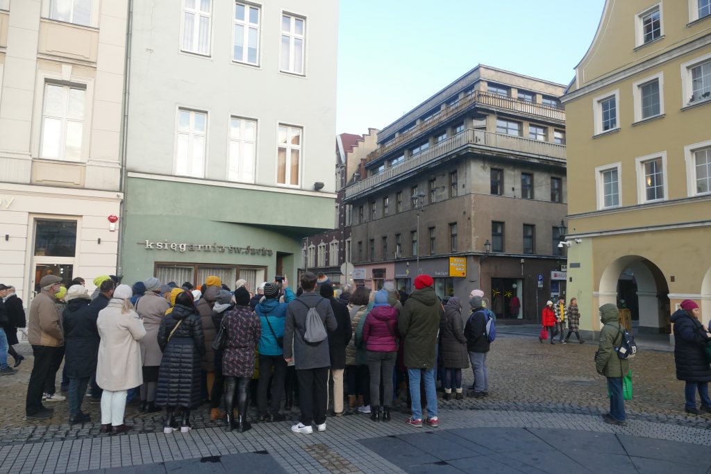 Duża grupa ludzi stojąca przy budynku